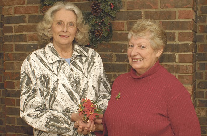 Life long friends Clara Anne Eaton and Mary Rose Dickey hold a Christmas poinsettia gift topper that they exchange every year as a way to keep in touch and renew their lasting friendship. Both ladies live south of Jefferson City and have been friends for over 50 years.