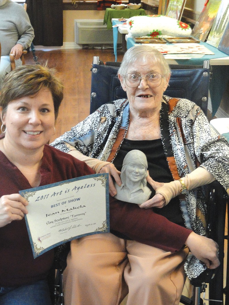 (Left) Tammy Gillespie, of Fulton, shows her mother's award during last year's Art is Ageless art competition. The late Jean Makela won Best of Show for her sculpture, and it was featured in the Presbyterian Manors of Mid-America's 2012 Art is Ageless calendar. Entries for this year's Art is Ageless are due by Jan. 31.                               