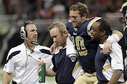 St. Louis Rams quarterback Kellen Clemens is helped off the field after being injured as Rams head coach Steve Spagnuolo, left, looks on during the fourth quarter of an NFL football game Sunday, Jan. 1, 2012, in St. Louis. The 49ers won 34-27.