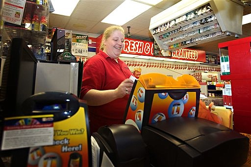 In this Dec. 31, 2011, photo, Amber Wallenstein, a 31-year-old clerk at the Freedom Value Center convenience store and gas station in Sioux Falls, S.D., rings up a Powerball ticket for a customer. The price for Powerball tickets is set to double Jan. 15. "I don't think anybody knows about it yet," Wallenstein said of the price hike. "But they'll still pay for it."