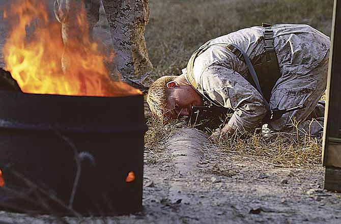 In this photo taken, Thursday, Oct. 27, 2011, a student investigates at the scene of a suicide bombing during a mock exercise at the U.S. Army John F. Kennedy Special Warfare Center & School at Fort Bragg, N.C. A scene of stomach-clenching gore confronted the special operations troops: The shredded remains of a suicide bomber, scattered around the checkpoint. But the blood and body are fake, like the Hollywood-style explosion that began a classroom exercise designed to teach these students to look past the grisly mess for the evidence that could lead to those who built the bomb.