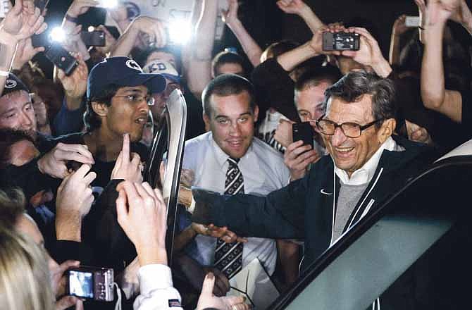 In this Nov. 8, 2011, file photo, Penn State coach Joe Paterno is greeted by supporters as he arrives at his home in State College, Pa.