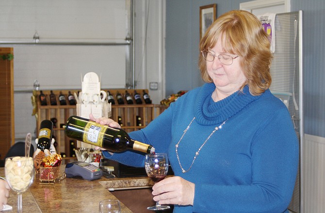 Regina Ruppert pours a sample of Touch of Black N Gold, a black currant merlot, at Serenity Valley Winery Saturday morning. Ruppert and her husband, Lee, moved their winery to the Millersburg area from O'Fallon in November.