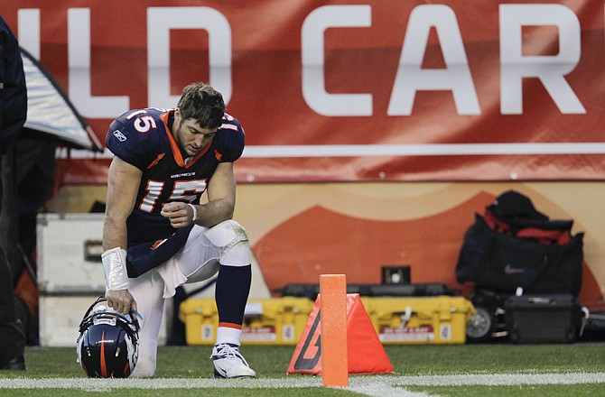 Broncos quarterback Tim Tebow kneels on the sidelines during the third quarter of Sunday's playoff victory against the Steelers.
