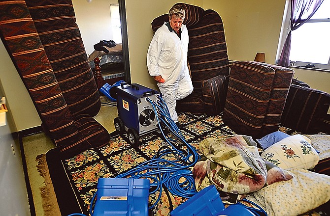 Larry Woods, manager of Atkins Pest Control, walks through an apartment in Dulle Tower while checking to make sure all of his heating units are working properly.