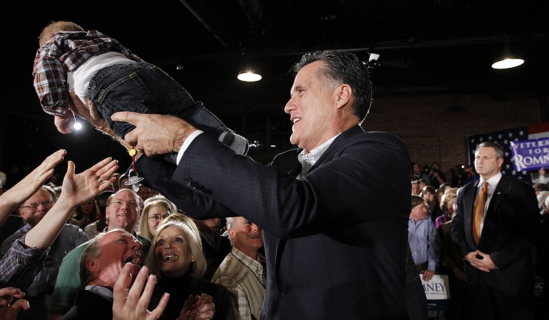 Republican presidential candidate Mitt Romney hands a baby back to the audience Wednesday as he campaigns at The Hall at Senate's End, in Columbia, S.C.