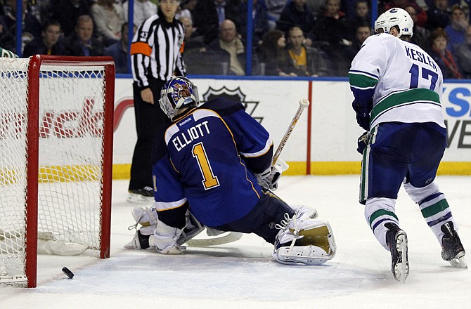 Ryan Kesler of the Canucks watches a shot by teammate Daniel Sundin slide past Blues goalie Brian Elliott during overtime Thursday night in St. Louis