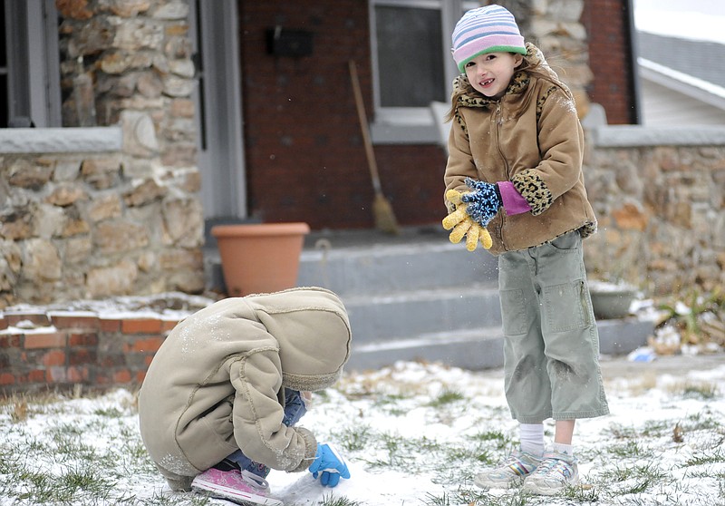 After spending the day off from school at their house, Hope Wise, 9, and Tru Wise, 7, build a snow mountain Thursday during their brief foray outside. The dusting of snow will likely melt quickly as weekend temperatures are expected to reach the 40s.