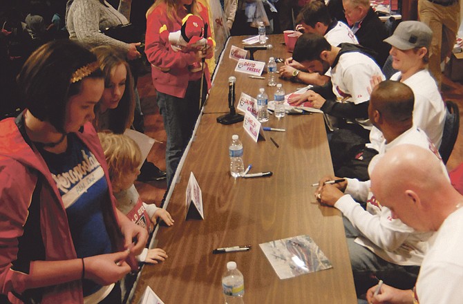 Members of the Cardinals Caravan sign autographs for fans Friday night at Richardson Auditorium in Jefferson City.