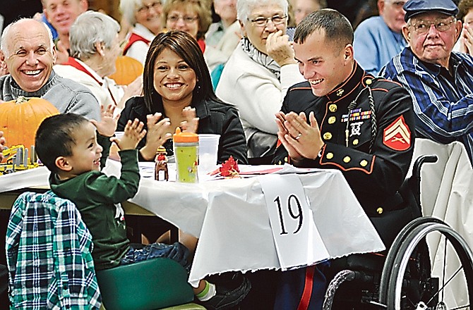 Lance Cpl. Tyler Huffman, center right, and his wife, Mellisa, clap with their son, Matthew, 2, during at the Veteran's Appreciation Night in November.