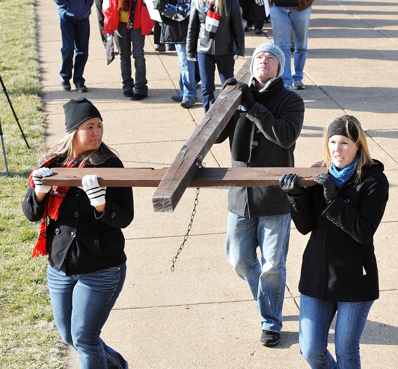 Anne Thompson-Coke, left, Tim Thompson and Rachel Gray carry a large cross to the Capitol during the MidWest March for Life that started at the Governor's Mansion and proceeded to the south lawn of the statehouse. 