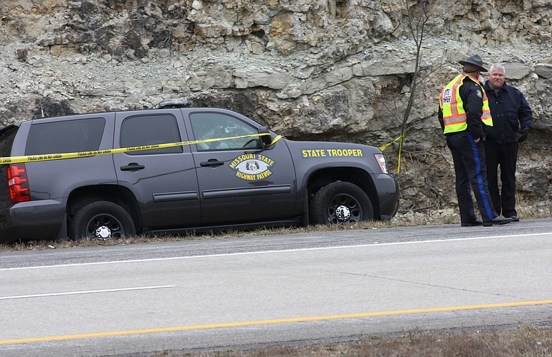 Holts Summit Police Chief Kyle McIntyre speaks with a Missouri State Highway Patrol officer Friday beside northbound Highway 54. On Friday morning, a highway patrol vehicle hit a suspect that was firing a weapon as he walked on Highway 54, the patrol reported.
