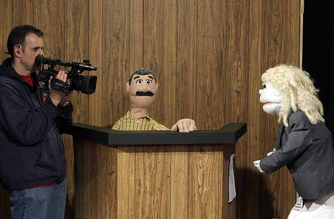 Cameraman Dave Spangler, left, films puppets reenacting testimony in a county corruption trial at the WOIO-TV studios in Cleveland Thursday, Jan. 19, 2012. The station uses the puppets performing as witnesses, reporters and jurors to detail the corruption trial against former Cuyahoga county commissioner Jimmy Dimora, which began last week in federal court in Akron.