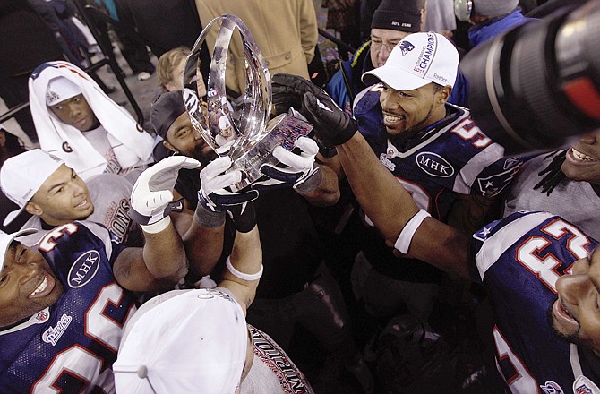 The New England Patriots celebrate with the AFC Championship trophy  in Foxborough, Mass. The Patriots defeated the Ravens 23-20.