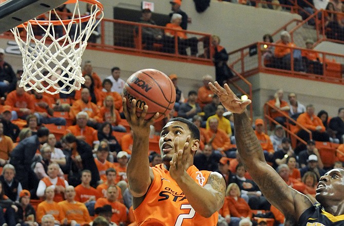 Oklahoma State guard Le'Bryan Nash shoots a layup past Missouri forward Ricardo Ratliffe during the first half of the Cowboy's 79-72 win Wednesday in Stillwater, Okla.