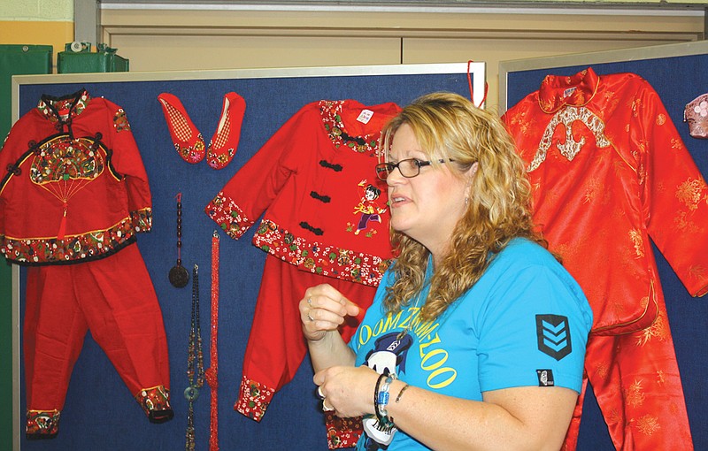 Susan Maddox, of Fulton, signs to Missouri School for the Deaf students Thursday about the traditional clothing of Taiwan. Maddox had a station about Taiwan set up at the school's Chinese New Year Festival. 