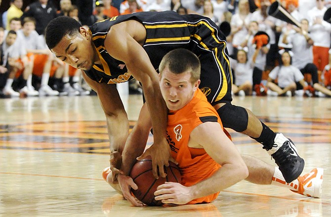 Oklahoma State guard Keiton Page and Missouri guard Phil Pressey struggle for a loose ball during Wednesday night's game in Stillwater, Okla.