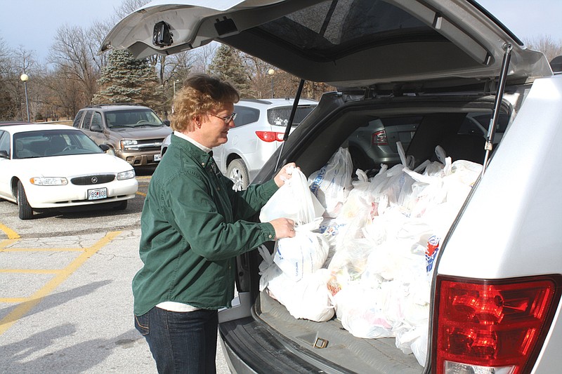 Donna Musgrove, with XVIII Wheelers Truck Washes, starts unpacking bags of food Friday morning for Bush Elementary School. Volunteers like Musgrove donate their time to help out the Buddy Pack program.
