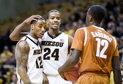 Missouri's Kim English, center, celebrates with teammate Marcus Denmon, left, as Texas' Myck Kabongo, right, looks on late in the second half of an NCAA college basketball game Saturday, Jan. 14, 2012, in Columbia, Mo. Missouri won the game 84-73.
