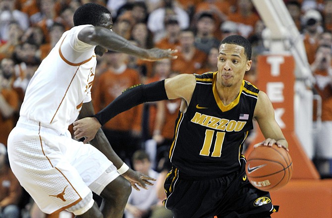 Missouri guard Michael Dixon drives around Texas guard Myck Kabongo during the first half Monday in Austin, Texas.