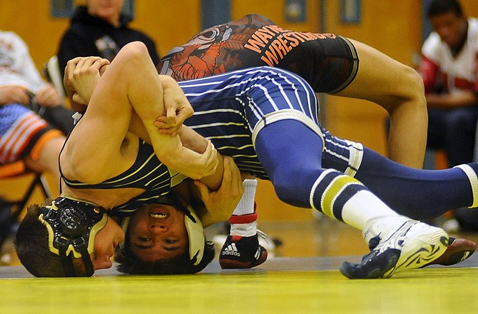Helias' Jacob Schulte works Waynesville's Andrew Wallace onto his back during Tuesday night's dual at Rackers Fieldhouse.