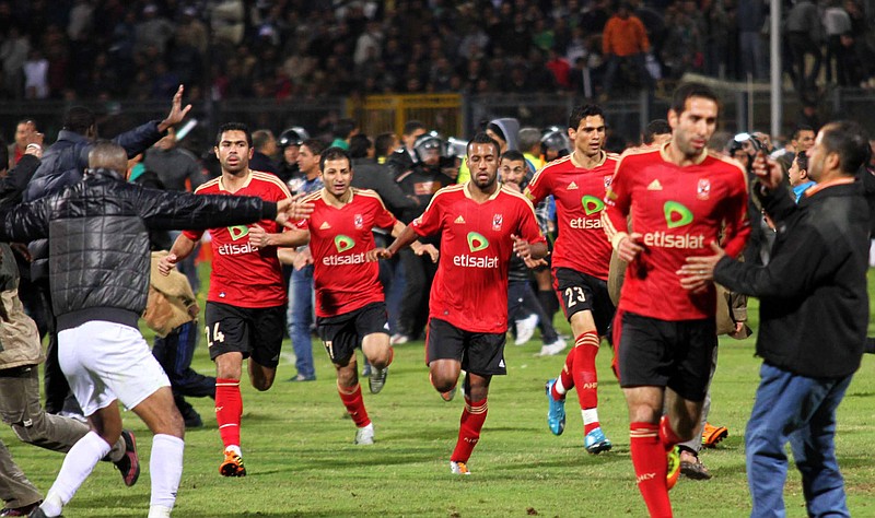 Team players of the Egyptian Al-Ahly club run for safety during clashes following their soccer match against Al-Masry club Wednesday at the soccer stadium in Port Said, Egypt. Dozens of Egyptians were killed Wednesday in violence following the soccer match, when fans flooded the field after the home team won an unexpected victory over Egypt's top club.