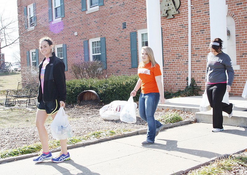 Members of the Alpha Phi sorority at William Woods University carry donations for the SERVE Food Pantry Thursday afternoon.