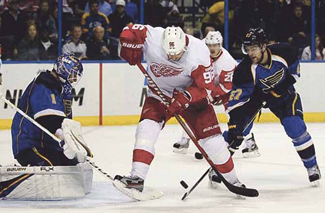 Detroit Red Wings' Tomas Holmstrom, of Sweden, cannot reach a loose puck as St. Louis Blues goalie Brian Elliott, left, and Alex Pietrangelo, right, defend during the first period of an NHL hockey game Tuesday, Nov. 15, 2011, in St. Louis.