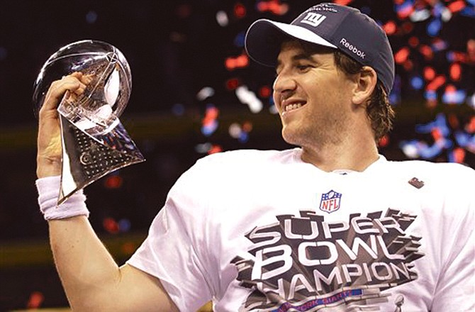 New York Giants quarterback Eli Manning celebrates with the Vince Lombardi Trophy after the Giants defeated the New England Patriots 21-17 to win Super Bowl XLVI.