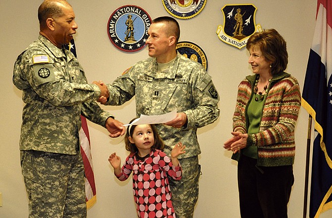 Capt. Alan Brown and his wife, Margie, and daughter, Maria, stand by as Brown prepares to receive the Missouri Commendation Ribbon for his service during state emergency duty in 2011.