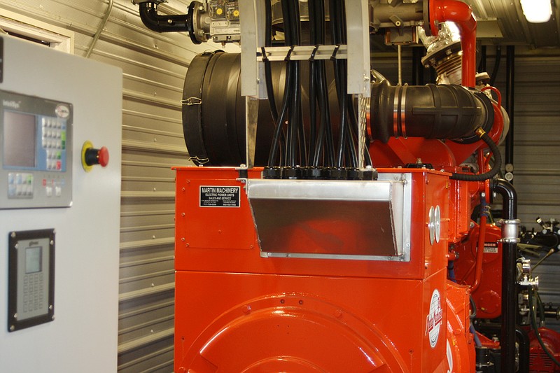 The new $450,000 generator and control panel is enclosed in a small steel building mounted on a concrete pad. The generator creates electricity by burning methane gas captured and piped from the closed Fulton landfill.
