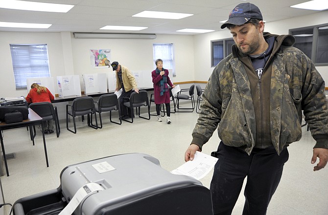 Greg Brandt casts his ballot after voting during his lunch hour Tuesday, at the Association of Missouri Rural Electrical Co-ops building on East McCarty Street.