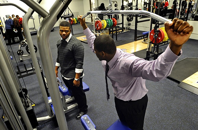 Lincoln University football players Jarian Wims (left) and Treston Pulley check out the new Magnum strength training machines during a reception following the grand opening and dedication of the Blue Tigers' new weight room Tuesday.