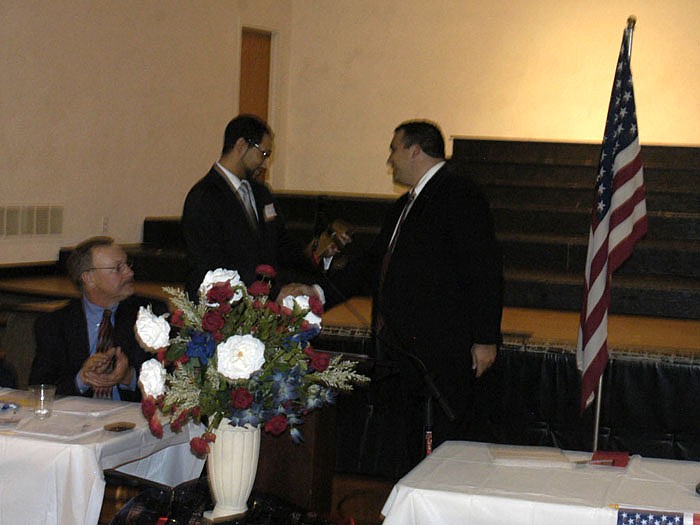 Shayne Healea, left, is presented the plaque for Republican of the Year by Republican Club President Caleb Jones at the Lincoln Day Dinner.