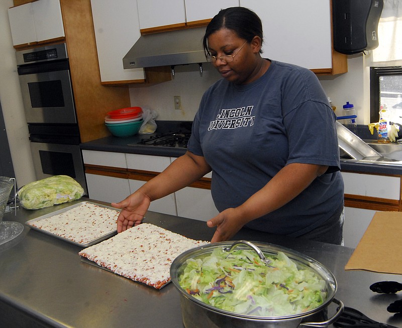 Tabitha Tarrant makes a fresh salad and pizza at the Boys and Girls Club on Monday. The club is serving dinner in a new program started by Executive Director Stephanie Johnson.