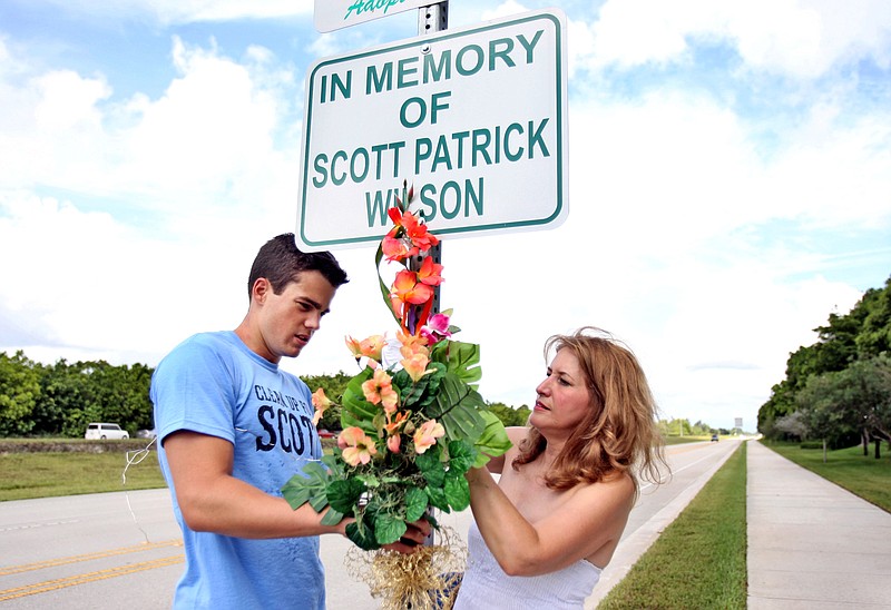 Scott Wilson's cousin Anthony Logan, and Scott's mother, Lili Wilson, attach flowers to a memorial in July 2010 in Wellington, Fla. Scott Wilson drowned after his car was allegedly hit and knocked into a canal by John Goodman. A lawyer for Lili Wilson said in a court filing that Goodman's adoption of his 42-year-old girlfriend was meant to disguise his true wealth should he be found liable and forced to pay punitive damages. 