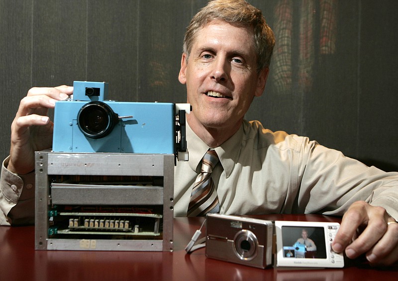 Steven J. Sasson in 2005 shows the prototype digital camera he built in 1975 next to Kodak's digital camera the EasyShare One, at Kodak headquarters in Rochester, N.Y. Despite inventing digital cameras, Kodak will stop making them and focus on printing technology.