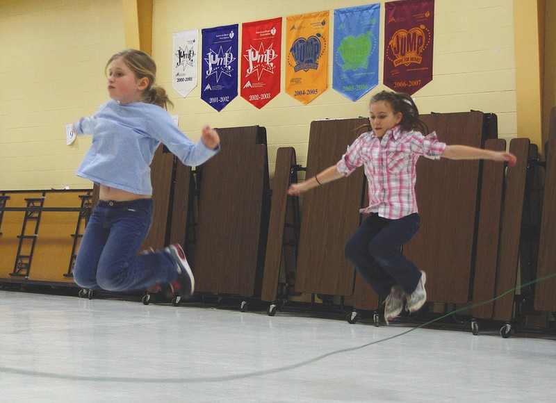 Fourth-graders Mikayla Burton and Amber Miller jump rope together during their P.E. class Thursday at McIntire Elementary School. The school is involved in the Jump Rope For Heart challenge to raise money for the American Heart Association.