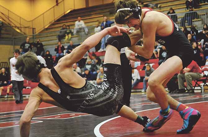 Hunter Neighbors of the Jays (right) takes down Rock Bridge's Jason Kiehne during action Saturday in the district tournament at Fleming Fieldhouse.