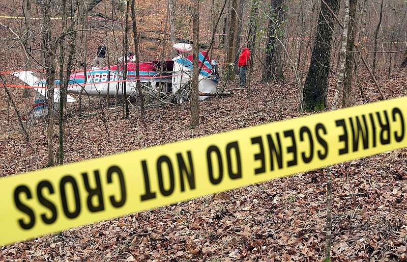 Investigators examine the scene of a plane crash Tuesday in North Monroe County, Mississippi. The pilot was found alive in the small plane after calling for help on his cellphone.
