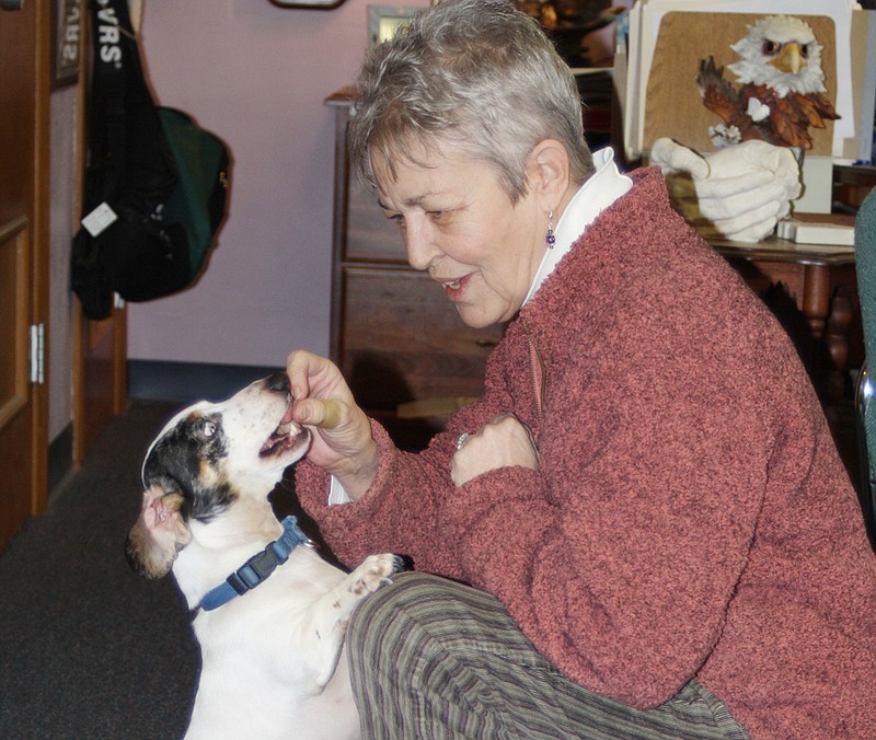 Barbara Garrison, superintendent of the Missouri School for the Deaf in Fulton, feeds a treat to Sparky, a deaf dog who is a favorite of students at the school. Sparky understands some sign language.