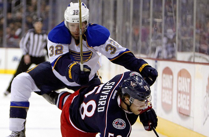 Chris Parter of the Blues knocks David Savard of the Blue Jackets to the ice during Tuesday's game in Columbus, Ohio.