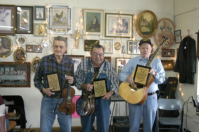From left, local jam session musicians Jim Donley, Louie Wacker and Bob Belt on Friday, Feb. 10, hold their instruments and country music plaques received for 15 years of enjoyment and entertainment.
