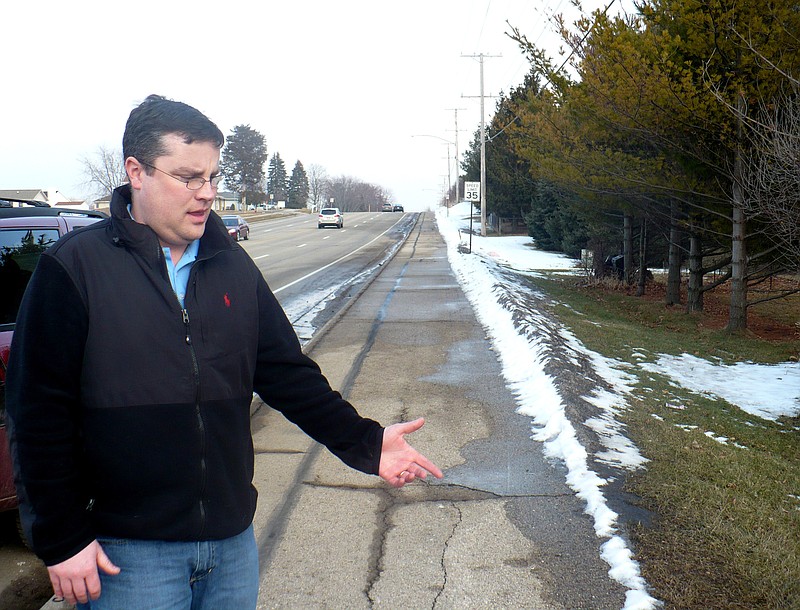 Mike Vega points Wednesday to the area of sidewalk in Madison, Wis., where he discovered a starving 15-year-old after she escaped from her abusive father and stepmother last week. 