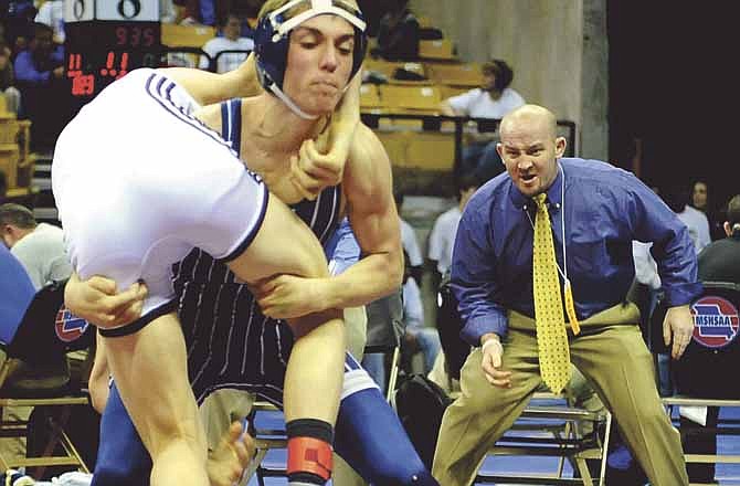 Helias coach Travis Reinsch yells instructions to the Crusaders' Logan Shea as he lifts Farmington's Brenden Briese off the mat during a 132-pound match Thursday at Mizzou Arena. Shea won the match 4-3. 