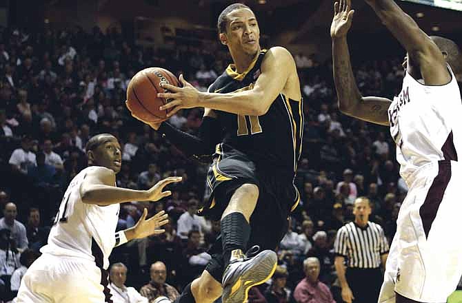 Missouri's Michael Dixon (11) looks to pass the ball as Texas A&M's Naji Hibbert, right, defends during the second half of an NCAA college basketball game Saturday, Feb. 18, 2012, in College Station, Texas. Missouri won 71-62.