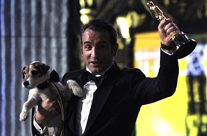 Jean Dujardin holds Uggie the dog after "The Artist" won the Oscar for best picture during the 84th Academy Awards on Sunday.