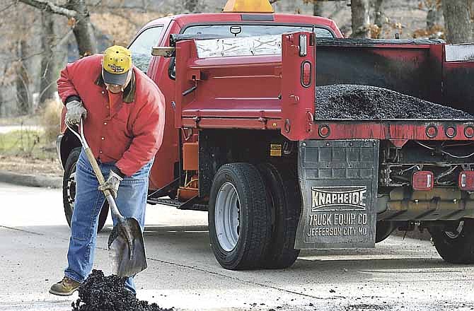 Bob Dippold fills potholes with cold mix asphalt and tamps it down while working on Roseridge Drive. Crews from the Streets Division of the Jefferson City Department of Public Works have been busy this week filling potholes and repairing broken concrete around the city. This year's mild winter is making it easier to keep up with the necessary work.