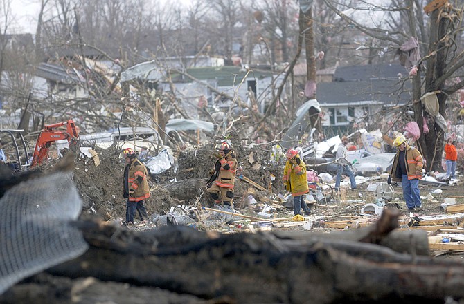 Emergency crews comb through some of the damage after a severe storm hit in the early morning hours on Wednesday in Harrisburg, Ill.