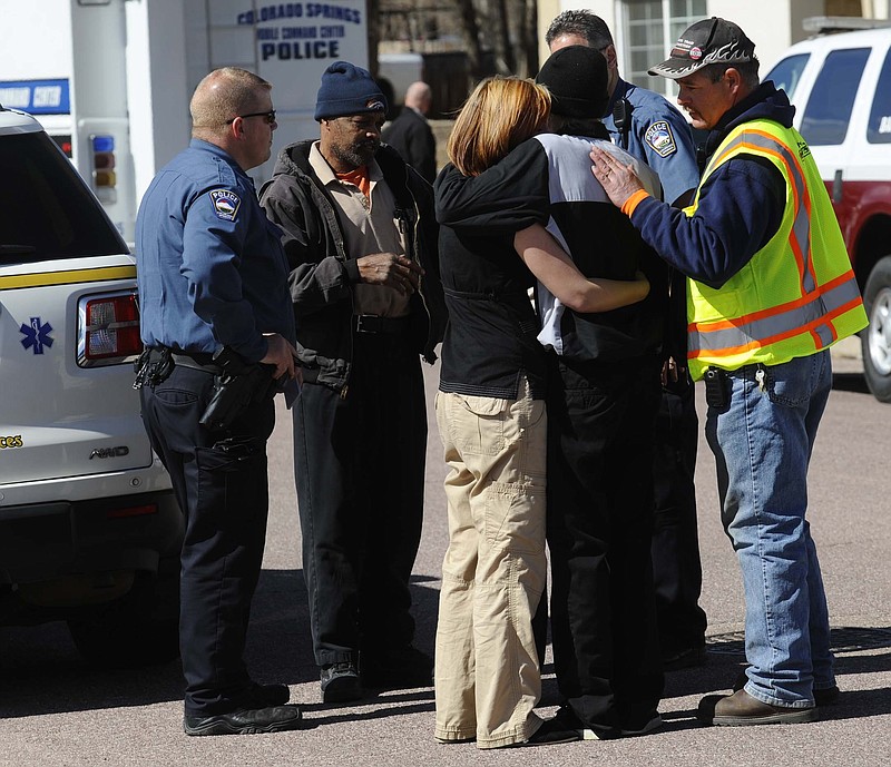 Employees are comforted after being released from a hostage situation Tuesday inside the Urological Associates office in Colorado Springs, Colo. The gunman has life-threatening injuries after being shot by a police officer.